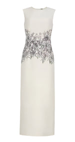 Introducing the Ophelia Silk Wool Dress by Adam Lippes: a sleeveless ivory masterpiece with a fitted waist and elegant floral print at the midsection, gracefully flowing into a long skirt. Crafted from luxurious silk wool, it epitomizes timeless sophistication.