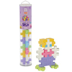 The Plus Plus Tube - BIG 15 Piece - Pastel is shown beside a colorful figure built from its interlocking blocks, offering creative STEM play and helping kids build fine motor skills.
