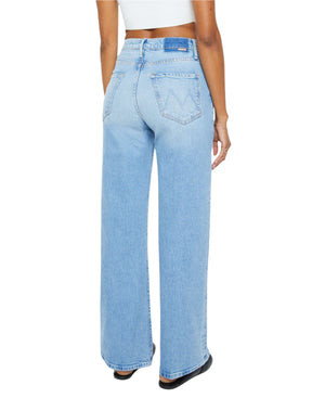 A person wearing Mother’s The Lasso Sneak super high rise wide-leg jeans in light blue SUPERIOR denim and a white cropped top, photographed from the back against a white background.