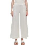 A person wearing Simkhai's Kallin Cropped Wide Leg Pant in heavy cotton and white sandals stands against a plain background.