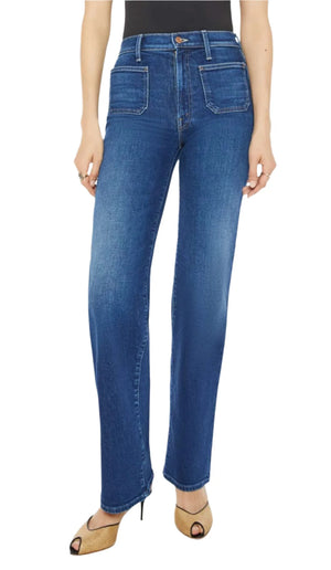 A person wearing Mother Denim Patch Pocket Rambler Zip Sneak, high-waisted blue jeans with a dark blue wash and two front pockets, paired with a black top and open-toe heels.