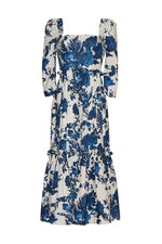 The Blue Hill Linen Dress by Cara Cara is a white dress with a blue floral print, featuring structured puff sleeves and a tiered skirt.