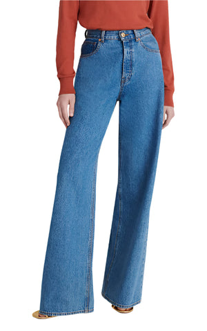 Someone is wearing a rust-colored long sleeve top with high-waisted, wide-leg Nariida Java Jeans by Blaze Milano in classic blue wash.