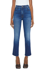 Wearing Mother’s The Hustler Ankle high-rise skinny-flare blue jeans with a white top and black mesh heels, the person stands against a white background.