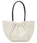 The Proenza Schouler Large Ruched Tote in cream showcases a sophisticated gathered top with dual black handles and a subtle logo stamp for added elegance.