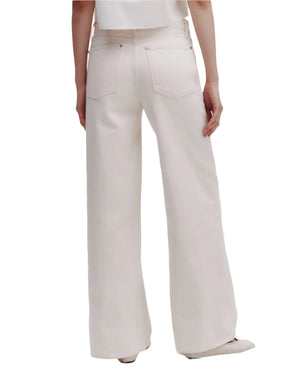Model wearing TWP Tiny Dancer Jeans in white, high-waisted with a wide leg, paired with a matching top and shown from the back against a plain background.