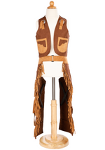 Displayed on a wooden stand, the "Cowboy Vest and Chaps, 7-8" from Great Pretenders captures the rugged essence of the West with its brown and tan fringed design.