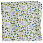 The Timo & Violet Shawl Blanket is a folded white organic cotton baby accessory with a playful print of monkeys, green leaves, and branches in shades of green, brown, and purple—ideal for adding style to any nursery.