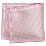 The Eton Geometric Silk Pocket Square features a pink hue, small geometric print, and thin border with the brand name in one corner. Made in Italy.