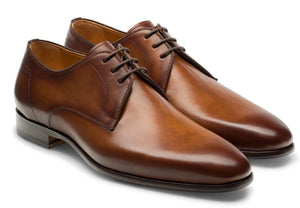 A pair of Magnanni Maddin Lace-Up brown calfskin plain toe derby dress shoes with a low heel and polished finish from the Línea Flex collection, displayed side by side on a white background.