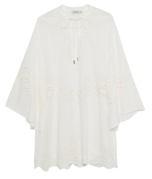 The Simkhai Sarina Mini Dress features broderie anglaise embroidery, a scalloped hem, wide sleeves, and a tie neckline—an airy, white piece perfect as a lightweight cover-up.
