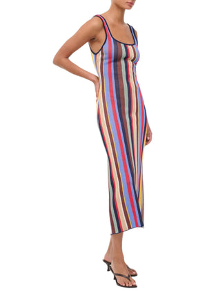 A woman wears the Staud Katie Dress, a sleeveless, scoop-neck style in compact knit with multicolored vertical stripes, paired with black sandals.