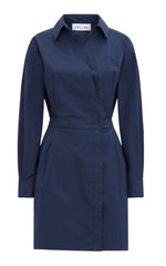 The Jaxina Dress by Callas Milano is a dark blue, long-sleeve shirt dress made from premium Italian cotton. It features a collar, front pocket, waist tie, straight hemline, and visible brand label inside the collar.