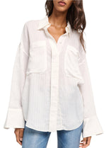 An oversized white shirt from the Dorothee Schumacher "Cool Stripe Blouse" collection, featuring a classic collar, wide cuffs, and two front pockets, paired with blue jeans.