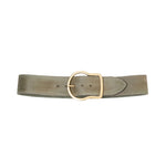 The Suede Sensation Belt by Dorothee Schumacher, a wide light olive green leather belt with a waxed finish and a rounded gold buckle, is displayed on a white background.