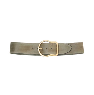 The Suede Sensation Belt by Dorothee Schumacher, a wide light olive green leather belt with a waxed finish and a rounded gold buckle, is displayed on a white background.