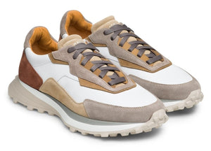 The Magnanni Onyx Sneaker features a modern mix of beige, brown, white, and tan panels with grey laces and textured soles, highlighting luxury design on a white background.