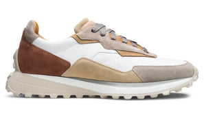 A side view of the Magnanni Onyx Sneaker, featuring white, beige, tan, and onyx brown suede and leather panels with a chunky sole and grey laces, highlighting its refined luxury design.