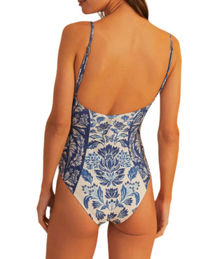 A woman is shown from the back against a white background wearing the Farm Rio FR Delicate Tapestry One Piece, featuring blue and white floral patterns.
