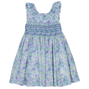 The Kidiwi Baby Girls' and Girls' Mélina Smocked Dress features a floral pattern, 100% cotton, with a ruffled neckline and smocked bodice in blue and purple shades.
