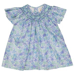 The Girls' Bergenie Smocked Blouse by Kidiwi is a floral blue and green baby dress with butterfly sleeves, featuring a smocked neckline and delicate hand embroidery for added charm.