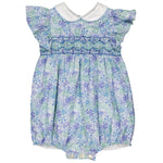 The Kidiwi Baby Girls' Julyne Smocked Romper is a delightful blue and purple floral outfit with a Peter Pan collar, ruffled sleeves, and elegant smocking.
