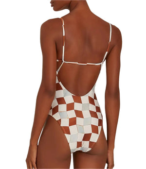 The individual is wearing the Lenny Niemeyer Back Strap One Piece swimsuit in a brown and white geometric-inspired casablanca print, showcasing its stylish back strap design from a rear view.