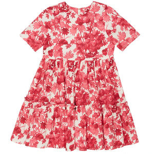 The Cara Cara Girls' Margaux Dress features short sleeves, a red and white berries floral print, a fitted bodice, and an A-line silhouette with a tiered, gathered skirt.