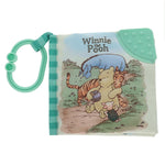 The Kids Preferred Classic Pooh Soft Book for babies features Pooh, Tigger, Piglet, and Eeyore on the cover and includes an attached teal teether and plastic ring.