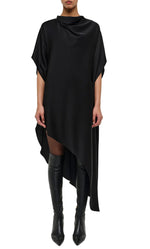 Wearing the Simkhai Sadia Cape Mini Dress—a loose-fitting, asymmetrical black mini with short sleeves, draped high neckline, and asymmetric hem—paired with over-the-knee black boots for a chic, modern glamour vibe.