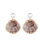The Jennifer Behr Folly Earrings showcase round crystal pearl studs with gold-rimmed brown natural seashell pendants, elegantly displayed on a white background.