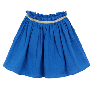 The Girls' Fotini Skirt by Arsene & Les Pipelettes is a blue, knee-length piece with a ruffled waistband, thin gold trim at the top, and a charming flare shape.