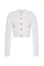 The Cara Cara Patty Cardigan is a white cropped piece with long sleeves, gold raffia buttons, two small front pockets, and a chic rib stitch design.