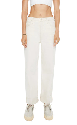 A person wearing Mother’s Spitfire Ankle Cuff off-white, high-waisted straight-leg jeans, a white cropped top, and beige platform shoes, shown from shoulders to feet. The jeans create a chic, modern silhouette.