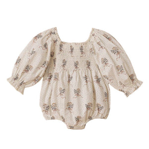 The Noralee Baby Girls' Autumn Romper features a smocked empire bodice, bubbled long sleeves, a square neckline, and a delicate floral pattern in light tones.