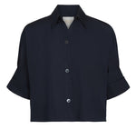 The Next Ex Shirt by TWP is a short-sleeved, dark navy button-up with a collar and chest pocket, made from vintage washed poplin in a relaxed boxy fit, showcasing three visible front buttons.