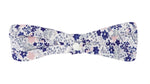 The Tartine et Chocolat Headband features a fabric bowtie with a blue, purple, and pink floral print on white—perfect for babies and beautifully displayed against a white backdrop.