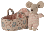 The Maileg Baby Mouse in Carry Cot - Rose features a small mouse in a pink knitted suit, resting beside a floral-patterned fabric carry cot with two handles.