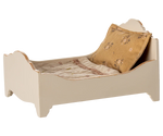 The Maileg Bed, Mouse - Off White is a small, cream-colored wooden bed with a patterned pillow and blanket, perfect as a cozy sleeping spot for mice.