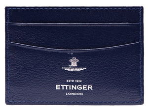 Close-up of a blue goat leather Capra Flat Credit Card Case by Ettinger, featuring multiple slots and "Ettinger London, ESTD 1934" in white logo text, highlighting its minimalist design.