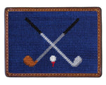 The Crossed Clubs Card Wallet by Smathers & Branson features a rectangular blue patch with two crossed golf clubs and a golf ball on a tee, bordered by brown stitching—ideal for a hand-stitched wallet or needlepoint card case.