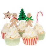 The Gingerbread Cupcake Kit by Meri Meri includes five cupcakes with white frosting and festive toppers: a star, gingerbread figures, a tree, and a candy cane, delivering holiday joy in each bite.