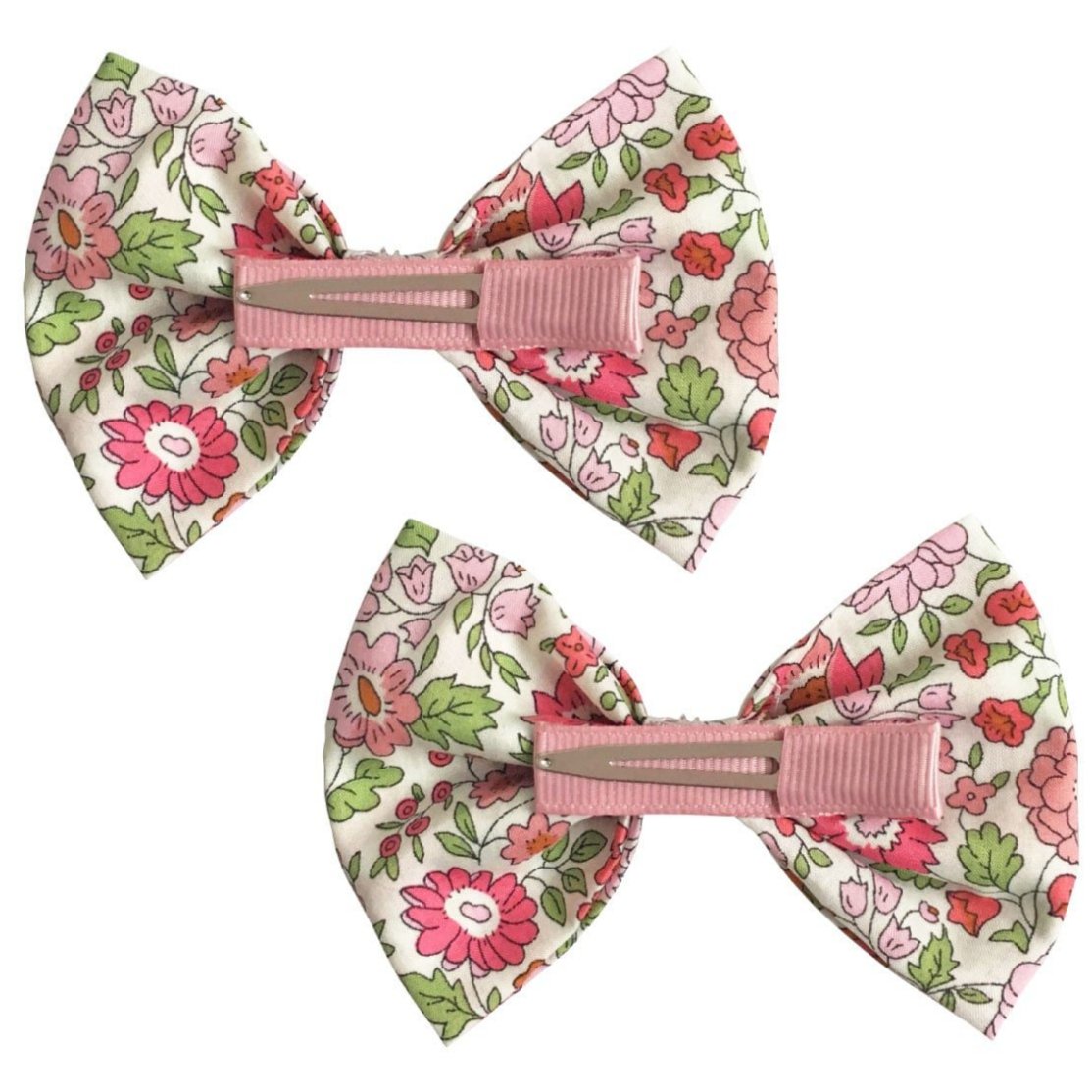 Set of two Milledeux Girls' Large Bowtie Bows in Liberty D’Anjo C fabric with pink, green, and red floral patterns, each featuring a pink clip on the back.