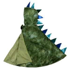 The Great Pretenders Dragon Cape is crafted from crushed velvet in a green, dinosaur-themed design, featuring a striking scales pattern with blue spikes along the back.