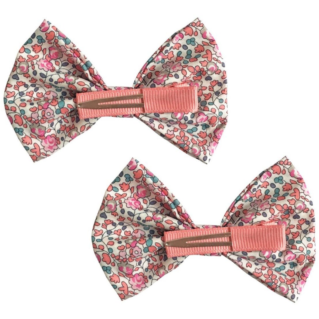 The Milledeux Girls' Large Bowtie Bows Liberty Eloise C feature two handmade fabric hair bows with pink, red, and blue floral Liberty of London fabric and pink textured center bands on alligator clips, shown against a white background.