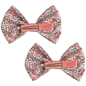The Milledeux Girls' Large Bowtie Bows Liberty Eloise C feature two handmade fabric hair bows with pink, red, and blue floral Liberty of London fabric and pink textured center bands on alligator clips, shown against a white background.