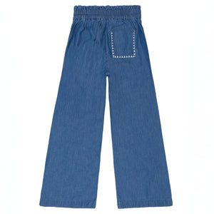 The Minnow Girls' Chambray Embroidered Paperbag Pant features blue denim, a comfy elastic waistband, wide legs, and a single back patch pocket with zigzag stitching.