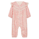 The Louise Misha Baby Girls' Lilany Jumpsuit features a pink base with a white floral pattern, long sleeves, lace shoulder details, ruffled armholes, button-down front, and elastic cuffs at wrists and ankles.