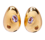 The Mini Arp Earrings by Lizzie Fortunato feature gold mini teardrops with an oval purple gemstone and a small round brown stone—ideal for everyday style or a polished boardroom look.