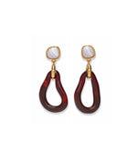 The Galina Earrings by Lizzie Fortunato feature gold and marbled white studs with large, irregular maroon resin hoops that dangle below, evoking the look of glass teardrop hoops.